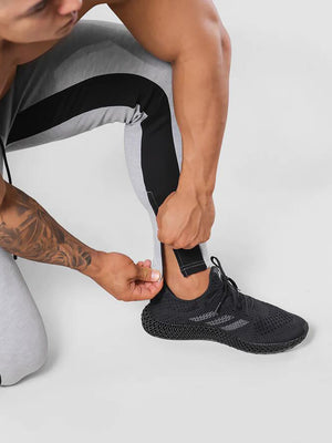 Man wearing ANVTT heather grey side stripe tapered jogger pants