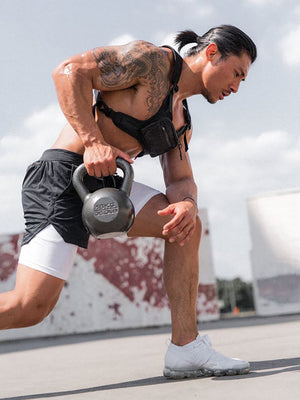Athletic man performing kettlebell deadlift wearing Anvtt men's black 
gym shorts – functional training activewear for strength and HIIT workouts